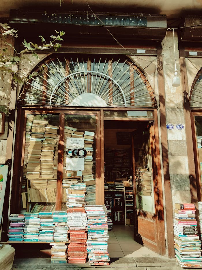 Explore this quaint, sunlit vintage bookstore with stacks of books welcoming you at the entrance.